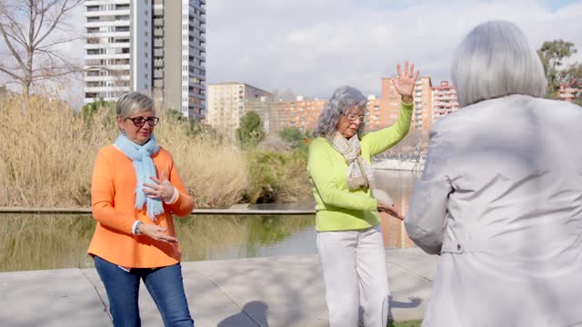Mature women learning Tai Chi in a park