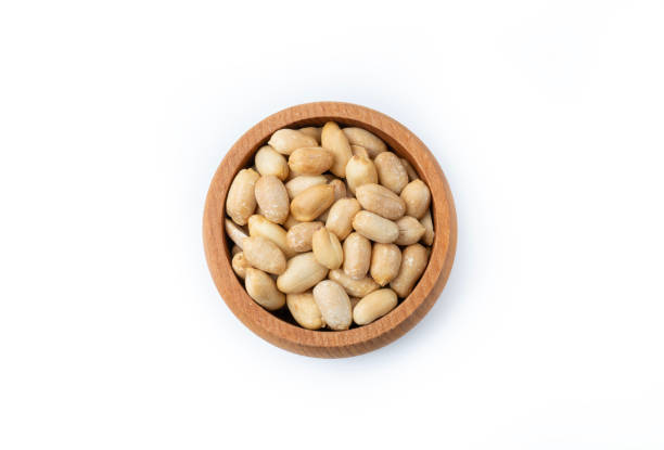 Peanut isolated on white background. Peanuts peeled in a wooden bowl. Vegetarian food concept. healthy snacks.