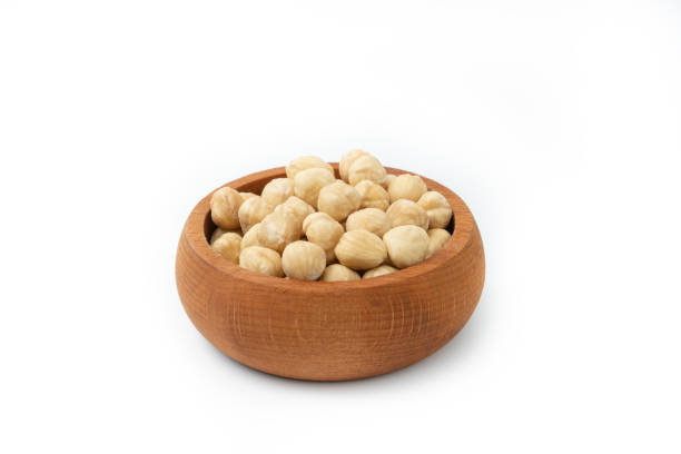 Peeled Roasted Hazelnuts in wooden bowl isolated on white background.Superfood. Vegetarian food concept. Healthy snacks