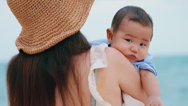 Mother Holding Baby on Beach, Serene Ocean vacation