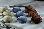Mochi cakes of three flavors on a stone board