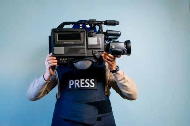 Reporter in bulletproof vest holding a video camera