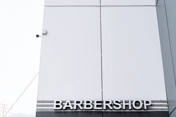 istock A barbershop sign, in a rectangular fixture, hangs on the building facade 2102353923