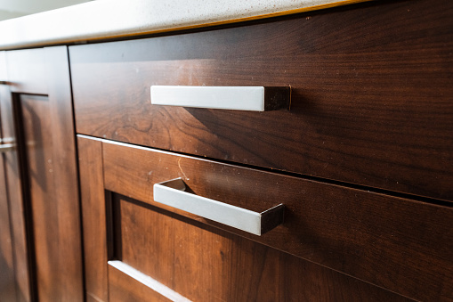 Close up of a wooden cabinetry with a white handle