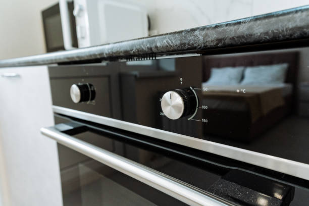 istock Home appliance, black oven in kitchen with bed in background 2102354493