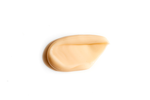 Self-tanning body lotion smear swatch. Self tanning cream or bronzer smudge isolated on white background.