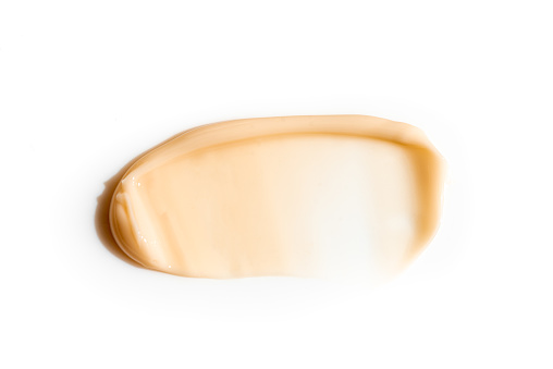 Self-tanning or sunblock body lotion smear swatch. Self tanning cream or bronzer smudge isolated on white background. Cosmetic texture.