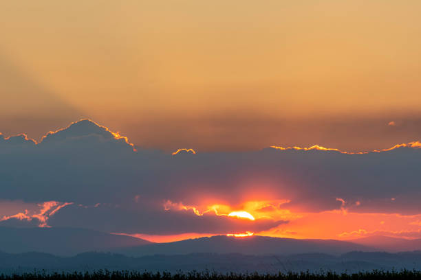 Sunset in the mountains with clouds and sunbeams. Landscape.