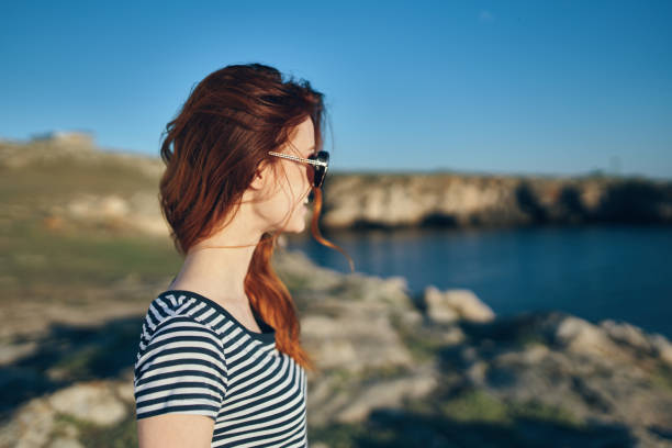 women blows near river look back and blue sky landscape side view. High quality photo