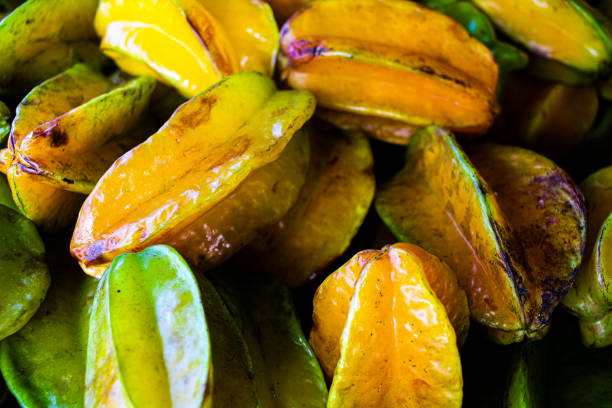 Starry Harvest A captivating close-up of a bunch of star fruit, each fruit resembling a celestial gem, capturing nature's intricate beauty in a colorful array of tropical delight. starfruit stock pictures, royalty-free photos & images