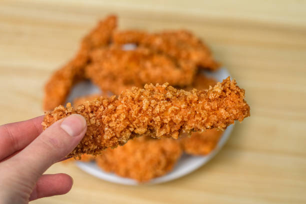 istock Crispy golden breaded chicken held in your hand 2102438070