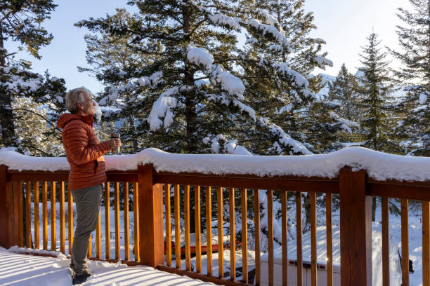Senior man enjoys hot beverage on veranda in winter