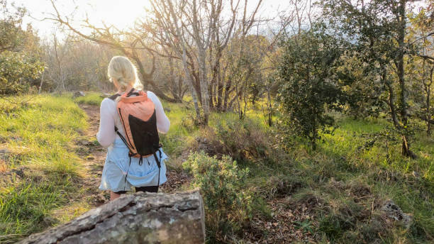 istock Mature woman hikes pathway in lush meadow 2102455916