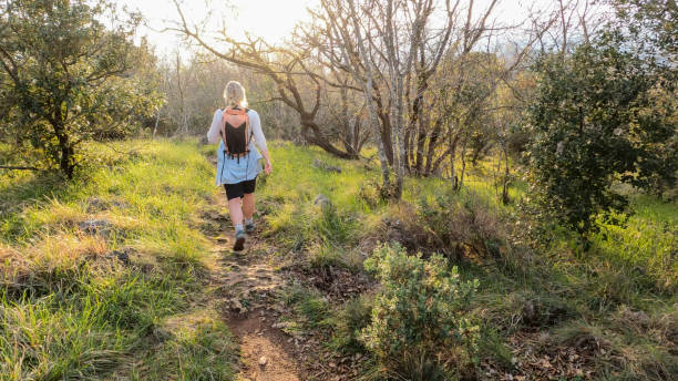 istock Mature woman hikes pathway in lush meadow 2102455935