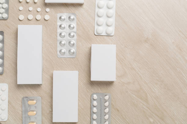 Flat lay with different pills in blister packaging and boxes and on wooden background