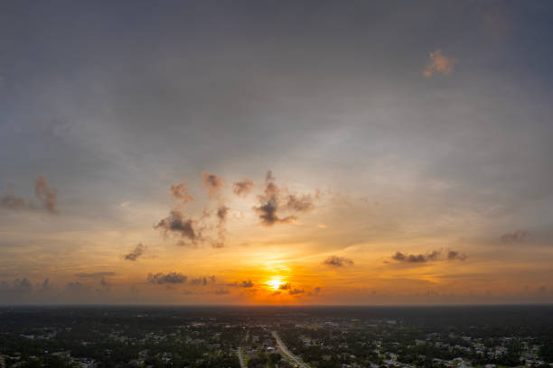 istock Bright sunset over dark rural land. Setting sun behind vivid orange and yellow clouds 2102472401