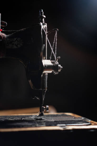 istock Old sewing machine stands on the table at home ready to work and sew. 2102498593