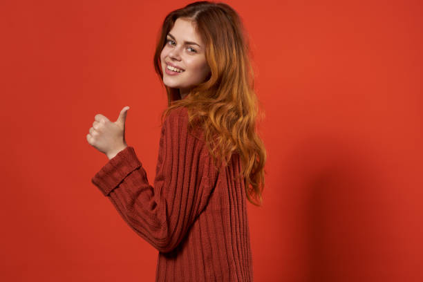 istock pretty woman gesturing with hands red sweater close-up studio 2102499116