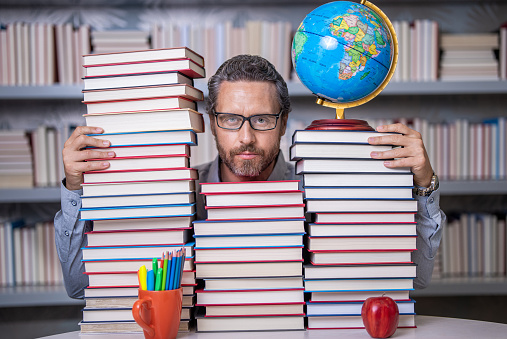clever school teacher. bookworm man in classroom. school teacher with book literature. education in school library. man bookworm get knowledge. teachers and knowledge day. The genius of innovation.