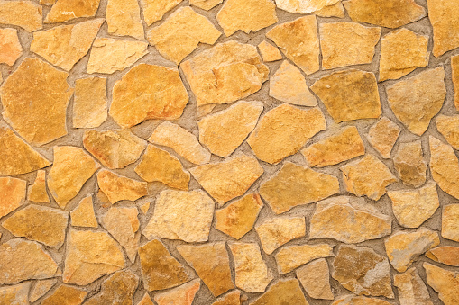 A close up view of a wall constructed entirely of interconnected rocks, showcasing their natural textures and patterns.