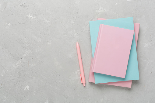 Notebooks with stationery on concrete background, top view