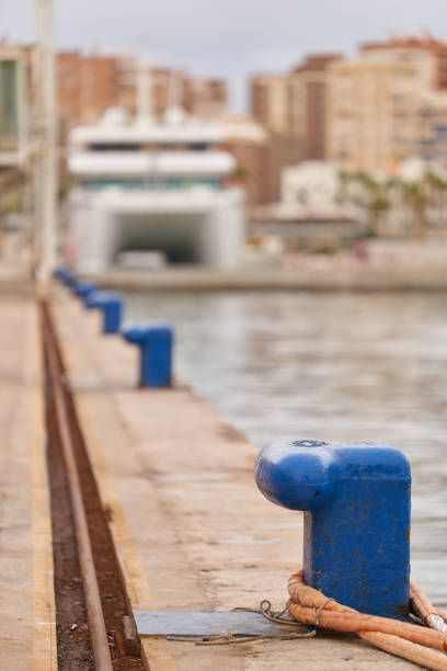 bollards with ropes mooring in the seaport with rusty rails vertical view sea view