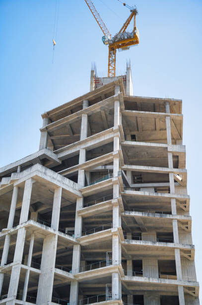 istock Skeleton of a Skyscraper with a Construction Crane atop the Summit 2102520026
