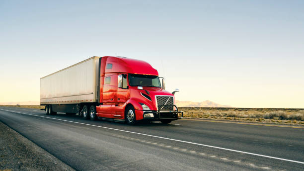Long Haul Semi Truck On a Western USA Interstate Highway Large semi truck hauling freight on the open highway in the western USA under a morning sky. semi truck stock pictures, royalty-free photos & images