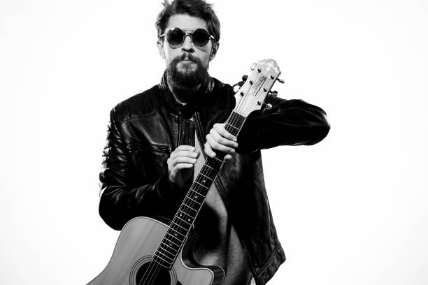 istock A man holds a guitar in his hands black leather jacket dark glasses music performance light background 2102526048