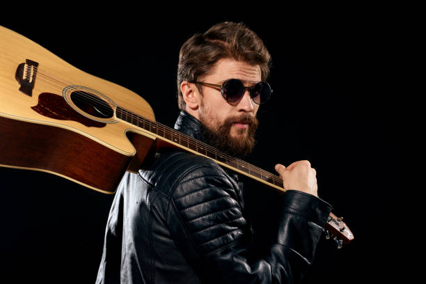 istock A man with a guitar in his hands leather jacket music performance rock star modern style dark background 2102531402