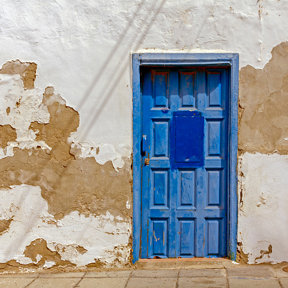 View of a Blue entrance door in dilapidated wall