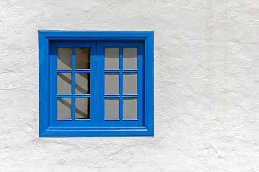 View of a blue window in a white wall