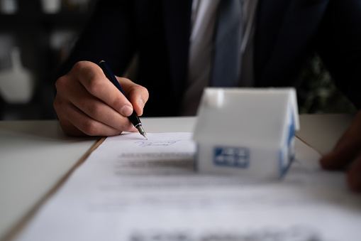 Businessman signing a legal real estate contract agreement, home Insurance.