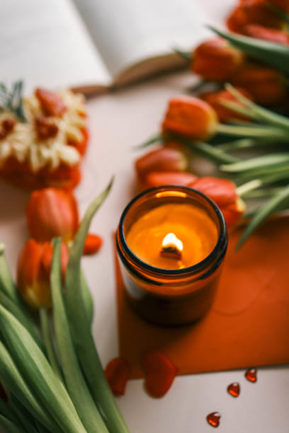 istock Candle and bouquet of red tulips, spring aesthetics 2102606182