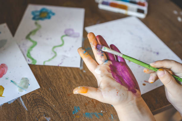istock Children's drawing workshop, happy children make handprints with paint 2102620715