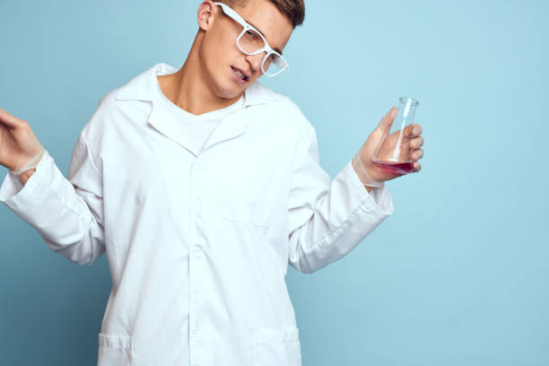 man holding flasks colorful liquid chemical laboratory model wearing glasses. High quality photo