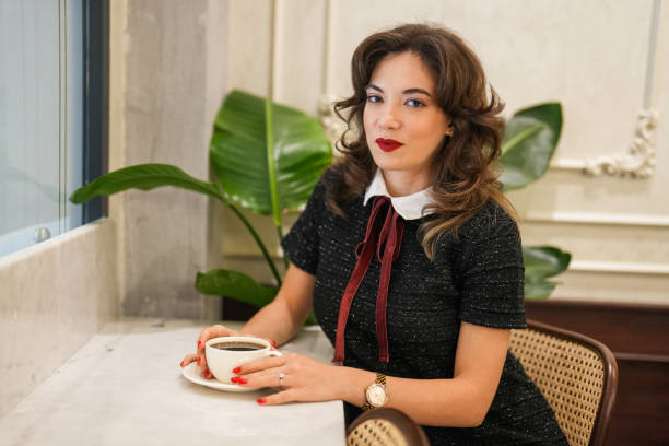 jeune belle femme buvant du café dans un café - restaurant business person setting the table clothing photos et images de collection