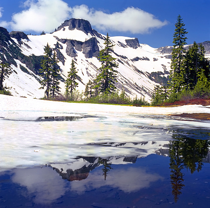 Mt Baker National Park, USA - a half-frozen lake in which a snowy mountain is reflected