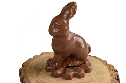 Easter milk chocolate in the shape of a rabbit on a wooden board.