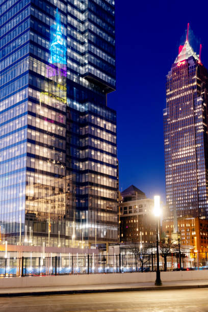This is an abstract photograph of the Terminal Tower reflection on the glass exterior of a tall modern building at twilight in downtown Cleveland, Ohio.