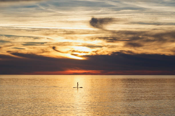 istock A boat sails through the water at sunset under the beautiful afterglow 2102695139
