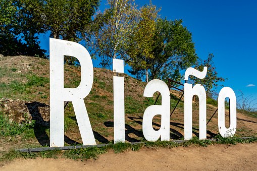 Sign of Riaño in a rural setting, tourist site of a reservoir of stagnant water from a dam in the Picos de Europa in the town of Riaño in León - Castilla y León - Spain.