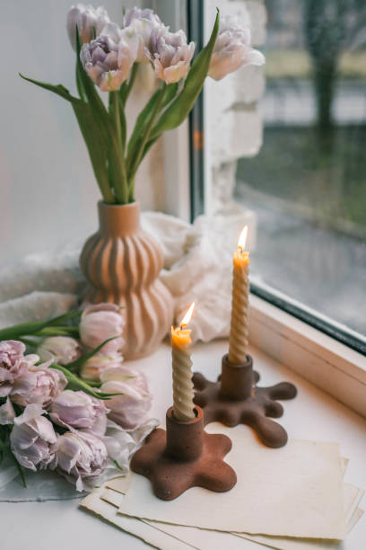 istock Spring aesthetics burning candles on candlesticks and pink tulips 2102708675