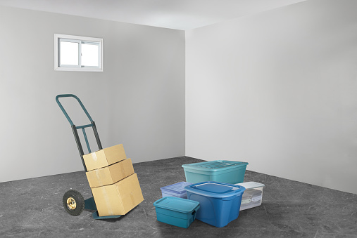Tote boxes and  hand truck with boxes on it for moving into a new home