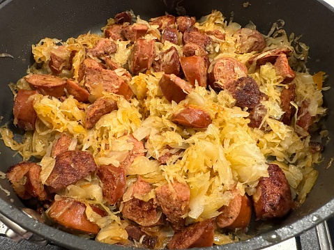 Kielbasa and sauerkraut browning on the stove