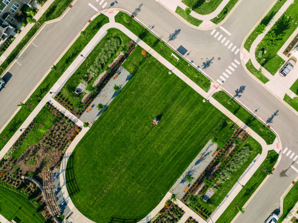 istock Elevated View of a Man Using a Riding Lawnmower to Cut Grass near an Apartment Complex with Copy Space 2102828882