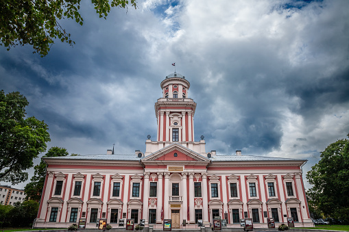 Jelgava, Latvia - August 17, 2023: Picture of the main facade of Academia Petrina on a cloudy sky in Jelgava, Latvia. Jelgava Gymnasium or Academia Petrina is the oldest higher educational establishment in Latvia. Based on an idea by Friedrich Wilhelm von Raison, it was established in Mitau, capital of the Duchy of Courland and Semigallia, by Duke Peter von Biron in 1775.