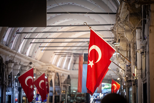 Picture of a turkish flags in the alleys of the Istanbul Grand Bazaar. Also known as Kapalicarsi, it is one of the largest and oldest covered markets in the world, ranked first among the world's most-visited tourist attractions. The Grand Bazar is often regarded as one of the first shopping malls of the world.