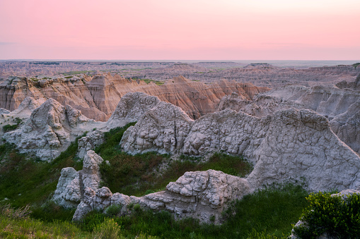 Badlands National Park in South Dakota consists of more than 242,000 acres of land. Dramatic landscapes including rock formations, steep canyons, towering spires and prairie grass are home to Bison, bighorn sheep and prairie dogs. Erosion has revealed sedimentary layers of purple and yellow (shale), tan and gray (sand and gravel), red and orange (iron oxides) and white (volcanic ash). It was designated a National Monument in 1939 and re-designated a National Park in 1978.