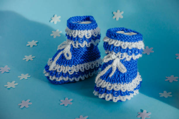 blue socks on newborn on blue background, knitted booties. High quality photo